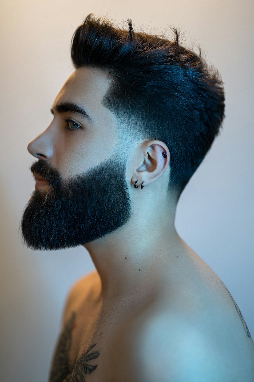 Profile of a man with a fade haircut blending into a beard