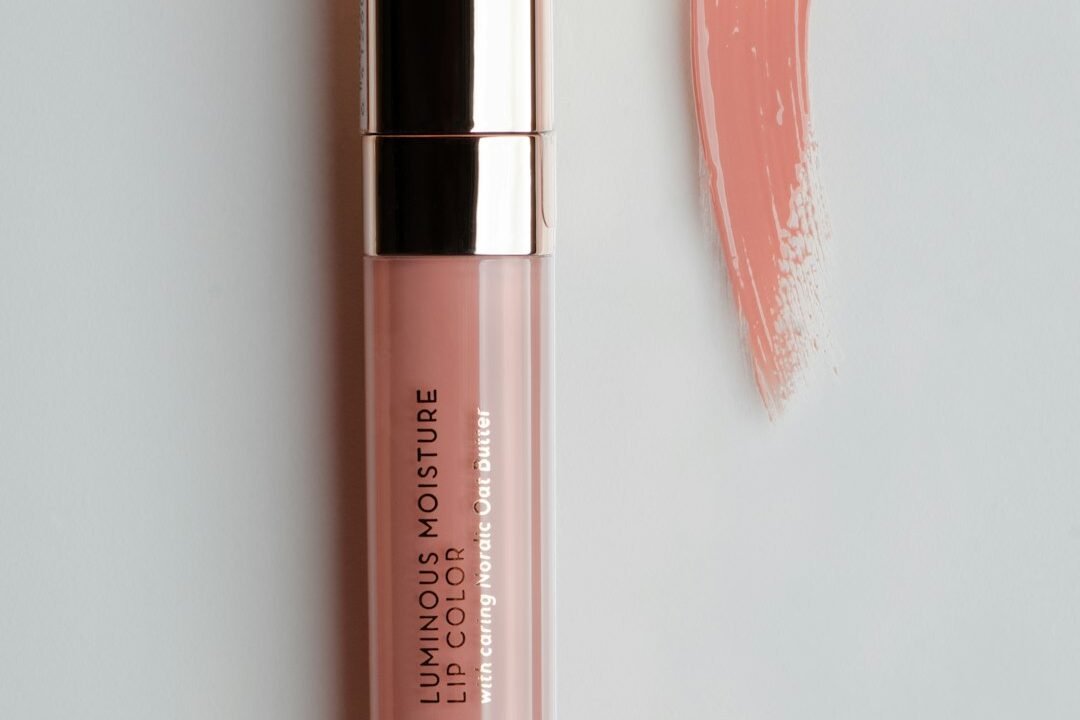 Pink lip gloss next to a lipstick tube